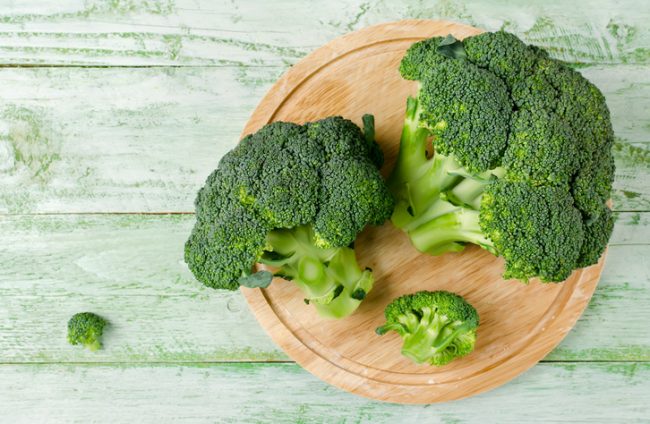 Two Heads of Fresh Broccoli on Cutting Board Being Prepared for Cancer Prevention Diet | Vitacost.com/blog
