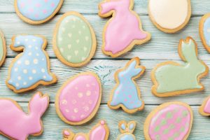 Easter sugar cookies with colored frosting on wooden table