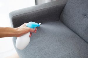 Woman Freshening Couch with Homemade Essential Oil Spray | Vitacost.com/Blog