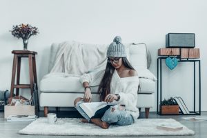 Woman Who Wanted to Clear the Clutter Sitting on Floor of Minimally Decorated Room | Vitacost.com/blog
