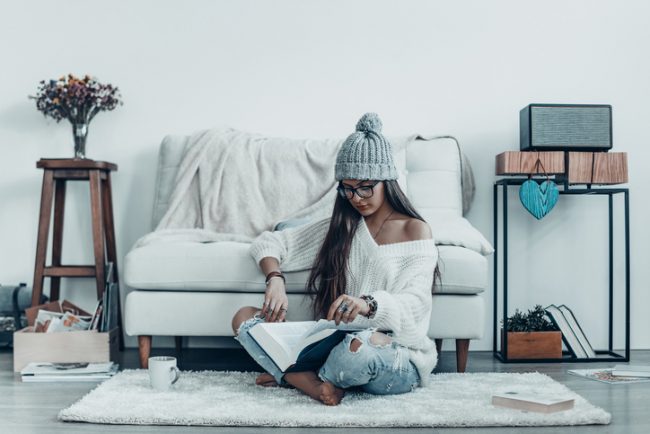 Declutter Your Home: 5 Ways it Benefits Health Woman Who Wanted to Clear the Clutter Sitting on Floor of Minimally Decorated Room | Vitacost.com/blog