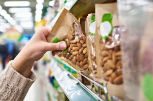 Hand Pulling Almonds in Plastic Food Packaging From Store Shelf | Vitacost.com/blog