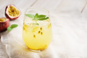 One Serving of Passion Fruit Iced Tea Beauty Drink with Collagen & Mint Leaves on Wood Counter #recipe | Vitacost.com/blog