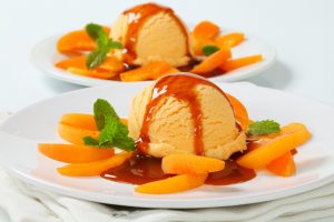 Bowl of Vegan Ice Cream with Balsamic Reduction Drizzle and Sliced Fruit