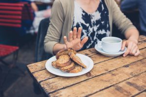 Woman Pushing Away Plate of Gluten-Containing Foods | Vitacost.com/Blog