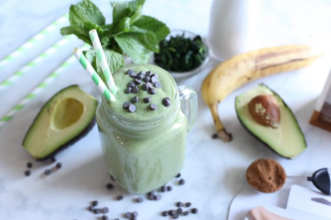 Mint Chocolate Chip Shake in Glass Jar with Ingredients Scattered Around | Vitacost.com/blog