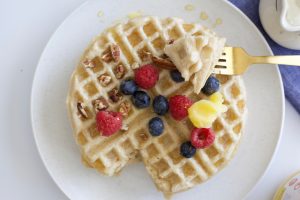 Overhead Shot of Butter Vegan Waffles on White Plate With Berries & Scoop of Nutiva Butter-Flavored Coconut Oil #recipe | Vitacost.com/blog