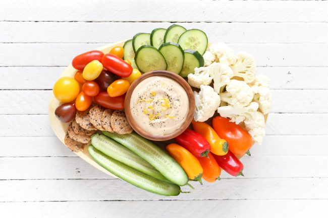 Oil-Free Hummus Dip on Platter Surrounded by Colorful Veggies