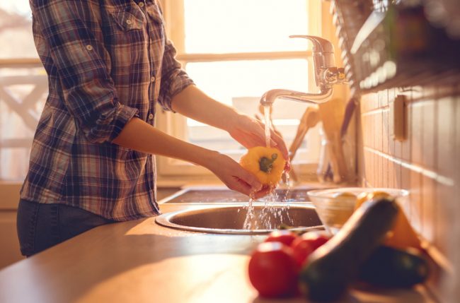 Woman at Sink Trying to Clean Pesticide Residue From Dirty Dozen Produce | Vitacost.com/blog