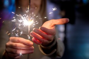 Woman Following Holiday Safety Tips Carefully Holding Sparkler on the Fourth of July | Vitacost.com/blog