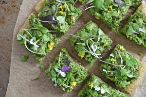 Cut Squares of Broccoli Pizza With Pea Pesto & Edible Flowers #recipe | Vitacost.com/blog
