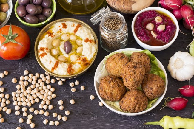 A Spread of Middle Eastern Paleo Food on Wood Table, Including Baba Ghanoush, Lamb Meatballs & More | Vitacost.com/blog