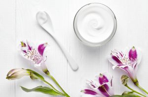 Jar of White Cream Surrounded by Flowers to Represent Plant Stem Cells in Advanced Skincare | Vitacost.com/blog