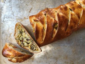 Breakfast stromboli with egg and sausage on cookie sheet