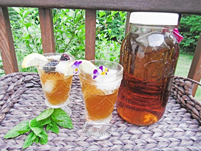 Homemade Sun Tea in Large Mason Jar and Drinking Glasses Garnished with Berries | Vitacost.com/Blog