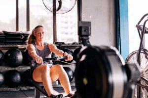 Blonde Woman in Her 30s Practices the Benefits of Rowing & Demonstrates How to Use a Rowing Machine | Vitacost.com/blog