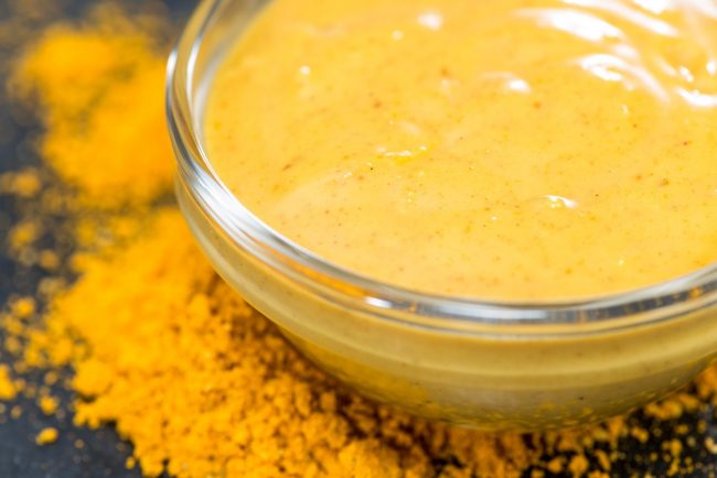 Coconut Curry Sauce Recipe (Paleo) Close-up of Coconut Curry Sauce in a Bowl With Curry Powder on Counter #recipe | Vitacost.com/blog
