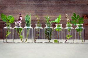 Row of Herb-Filled Glass Bottles Filled With Essential Oils for Headaches and Migraines | Vitacost.com/blog