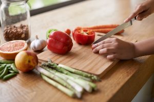 Person Chopping Vegetables on Cutting Board During Weekly Meal Prep | Vitacost.com/Blog