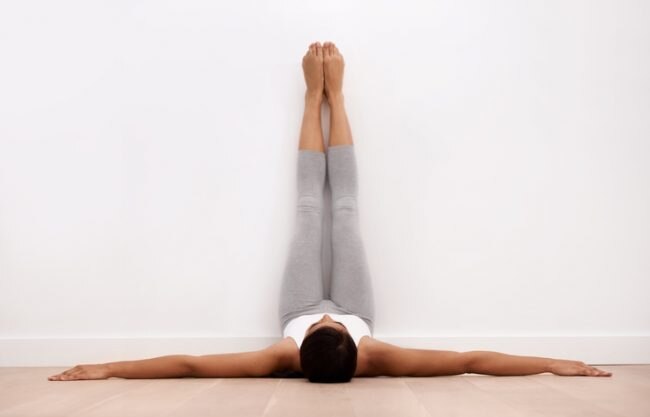 Woman Practicing Legs-Up-the-Wall Pose to Soothe During Post-Natal Yoga | Vitacost.com/Blog