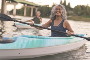 Smiling Senior Woman in Kayak Enjoying Exercise Outdoors as Part of Healthy Aging Plan | Vitacost.com/blog