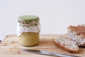 Jar of Hemp Butter Sitting on Cutting Board Next to Bread | Vitacost Blog
