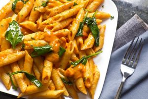 Pumpkin Pasta Sauce over Penne Pasta on White Dish | Vitacost.com/blog