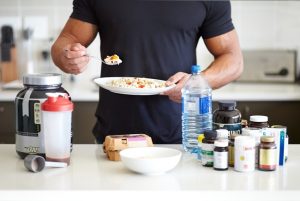 Muscular Man with Many Supplements May Experience Common Sports Nutrition Side Effects | Vitacost.com/blog