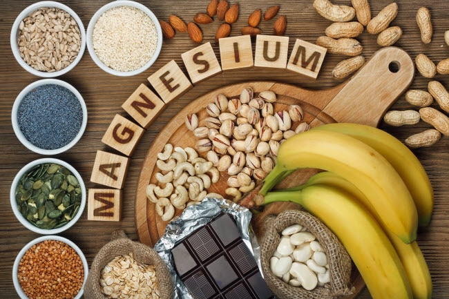 Assorted Magnesium-Rich Foods and Letters Spelling out Magnesium on Wooden Table Surface | Vitacost.com/blog