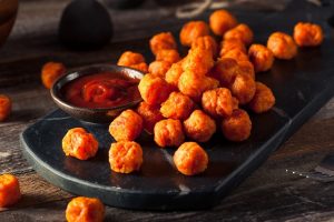 Homemade Sweet Potato Tots on Black Plate with Healthy Ketchup
