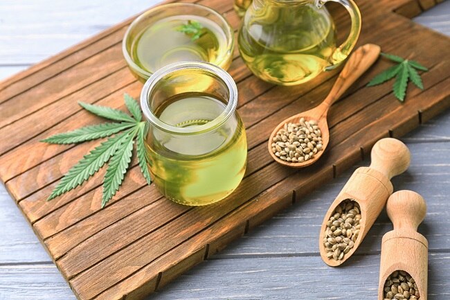 Hemp Oil Benefits & Uses for Skin, Diet & More Hemp Seed Oil in Glass Jar Surrounded by Hemp Leaves | Vitacost.com/Blog