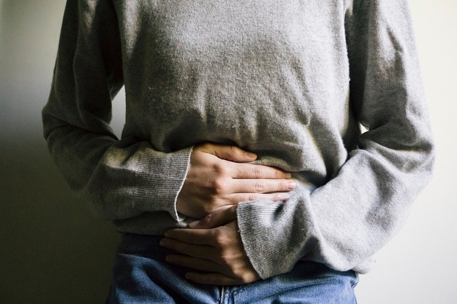Woman Experiencing Stomach Upset Holding Stomach | Vitacost.com/Blog