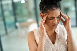 Woman Holding Temples in Pain Physically Suffering From the Effects of Stress | Vitacost.com/blog