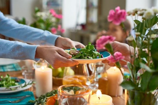 Dinner Guest Passing Dish at Vegan Thanksgiving Dinner Table | Vitacost.com/Blog