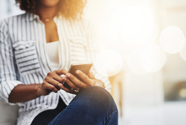 Does Your Cell Phone Pose Health Risks? Torso View of Seated Woman Concerned About Cell Phone Health Risks Looking up Information Online | Vitacost.com/blog