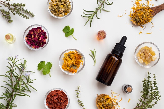 Herbalism Exemplified by Assortment of Colorful Herbs, Leaves and Tinctures on White Surface | Vitacost.com/blog