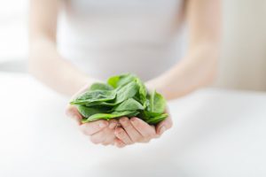 Woman Holding Pile of Calcium-Rich Greens That She Will Eat to Boost Bone Mass | Vitacost.com/blog