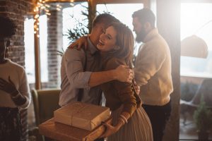 Woman Hugging Friend at Holiday Party to Cope with Social Anxiety | Vitacost.com/Blog