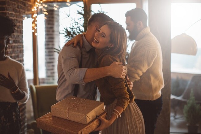 How to Overcome Holiday Stress & Social Anxiety Woman Hugging Friend at Holiday Party to Cope with Social Anxiety | Vitacost.com/Blog