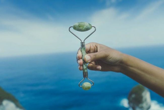 Woman Holding up Jade Roller | Vitacost.com/Blog