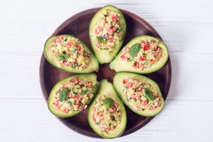 Halibut Ceviche Recipe Stuffed in Avocado Boats Arranged on Circular Wooden Dish on White Wooden Table | Vitacost.com/blog