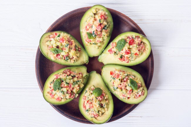 Halibut Ceviche Recipe Halibut Ceviche Recipe Stuffed in Avocado Boats Arranged on Circular Wooden Dish on White Wooden Table | Vitacost.com/blog