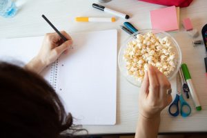 Woman Working at Office Desk Snacking on Healthy Chickpea Popcorn | Vitacost.com/Blog