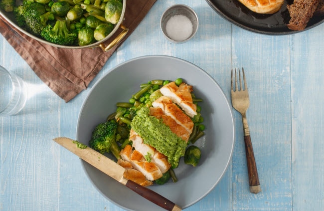 Overhead View of Dinner with Pesto-Stuffed Chicken and Vegetables on Blue Plate and Table | Vitacost.com/blog