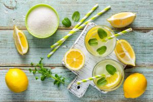 Overhead View of Fresh-Cut Lemons, Herbs, Sugar and Straws to Represent Natural Constipation Remedies | Vitacost.com/blog
