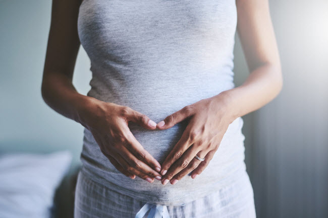 Pregnancy Woman Questioning Why Take Prenatal Vitamins Holding Hands in Heart Shape Over Her Belly | Vitacost.com/blog