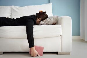 Woman Face Planted on White Couch Fighting Signs of Hormone Imbalance | Vitacost.com/blog