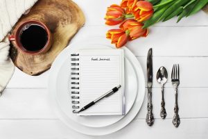 Does Calorie Counting Work for Weight Loss Exemplified by Food Journal at Place Setting on White Table | Vitacost.com/blog