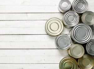 Overhead View of a Variety of Canned Foods In a Row on White Wooden Background | Vitacost.com/blog