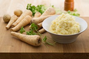 Bowl of Parsnip Mash Next to Raw Parsnips | Vitacost Blog